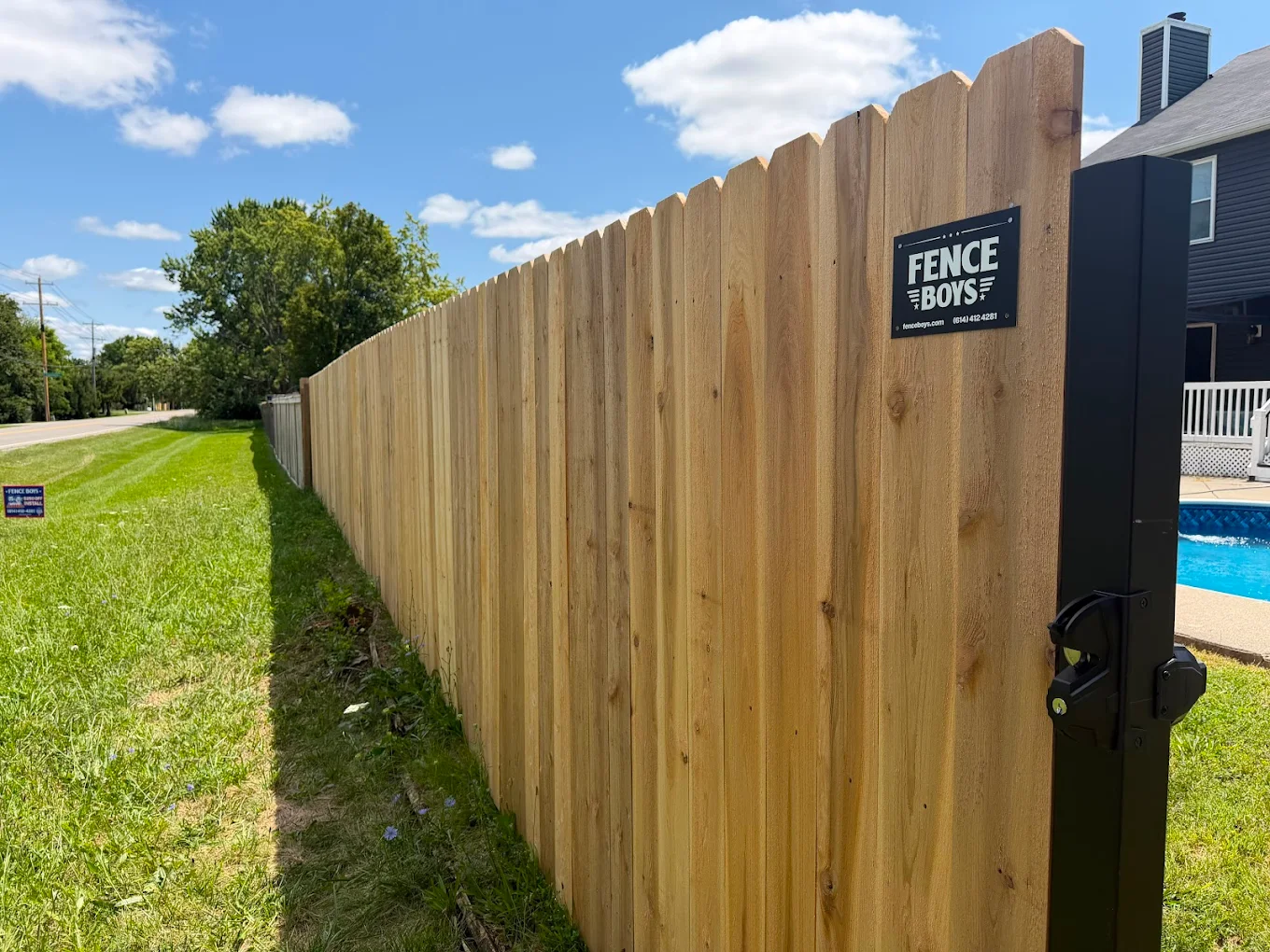 Cedar fence with gate against a clear sky