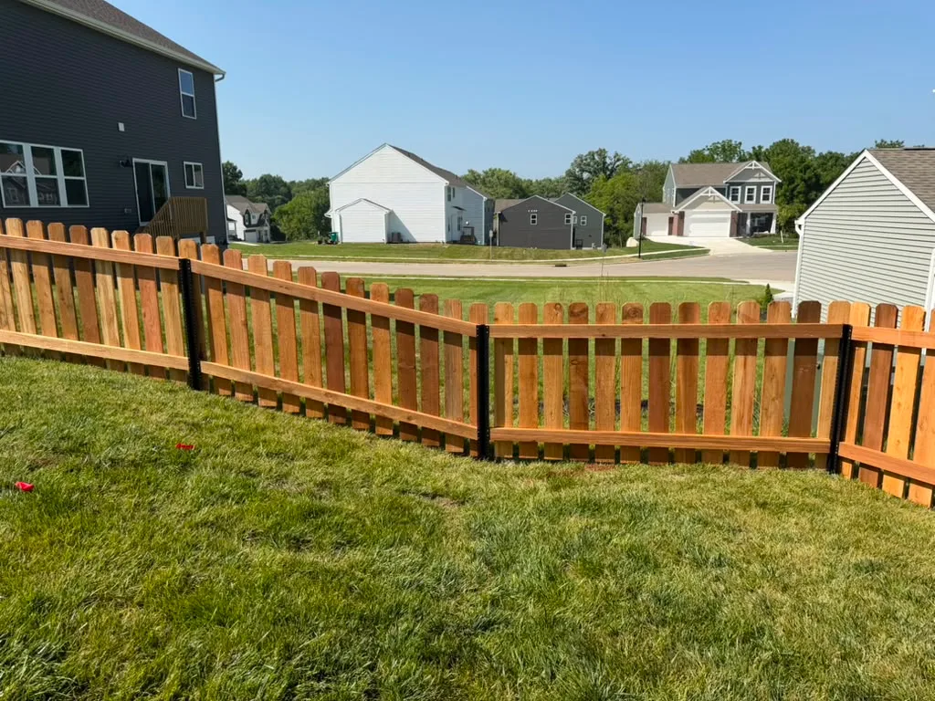 Fence enclosing a large back yard with open lawn