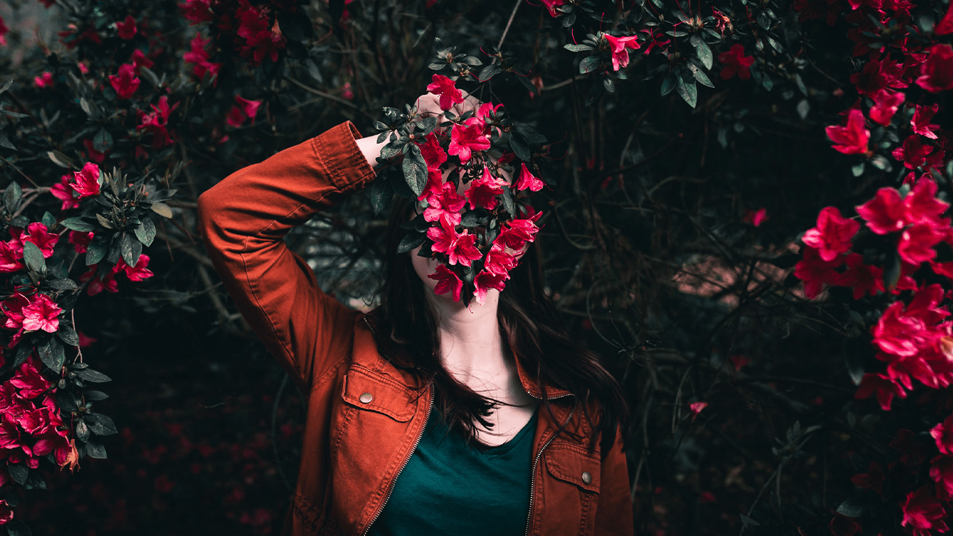 Woman hiding behind flowers