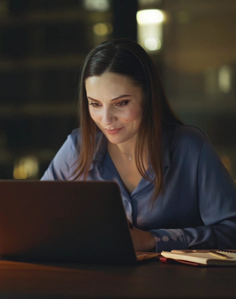 Person smiling at laptop screen