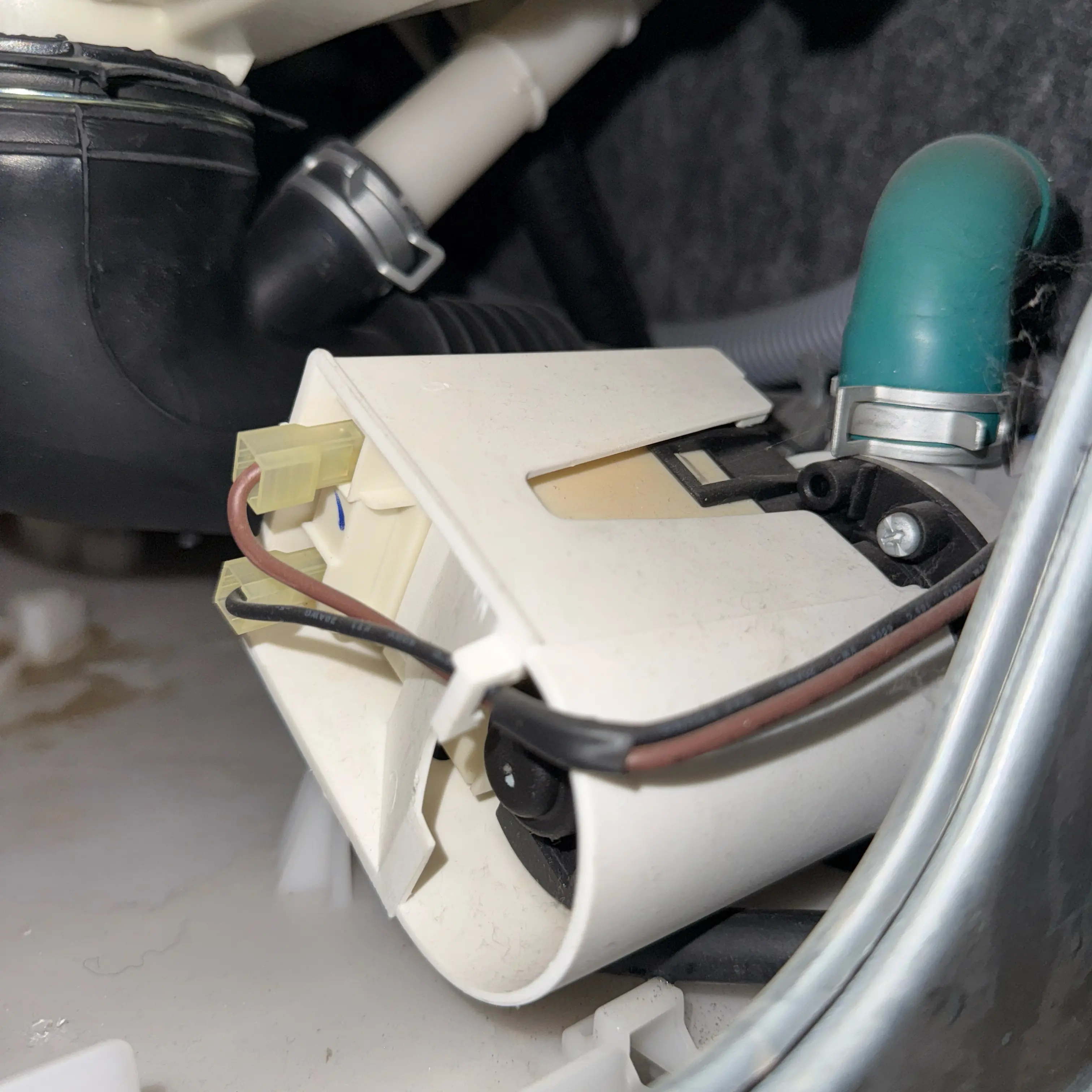 Electrical component with white casing, black and red wires, and pipes