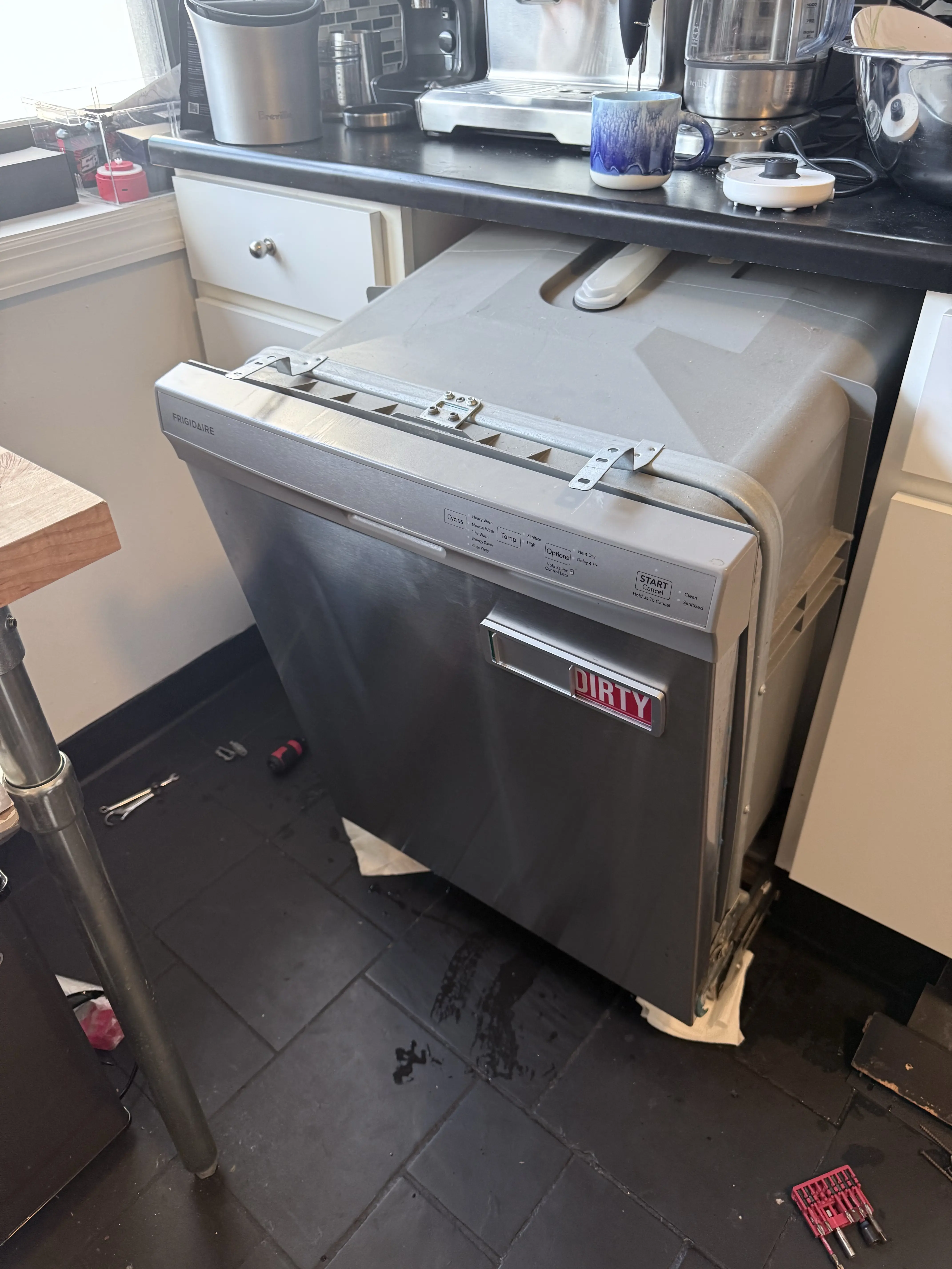 Stainless steel dishwasher with "DIRTY" magnet in a kitchen setting