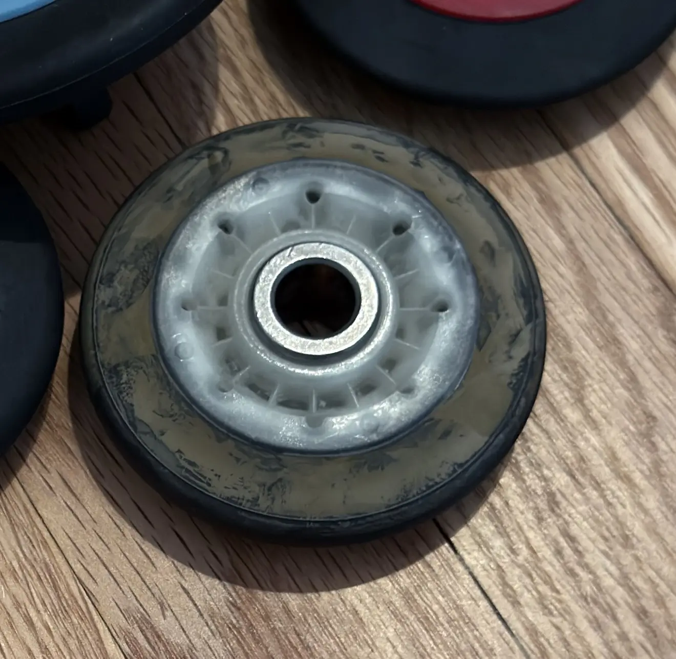 Inline skate wheel with worn rubber on wooden surface