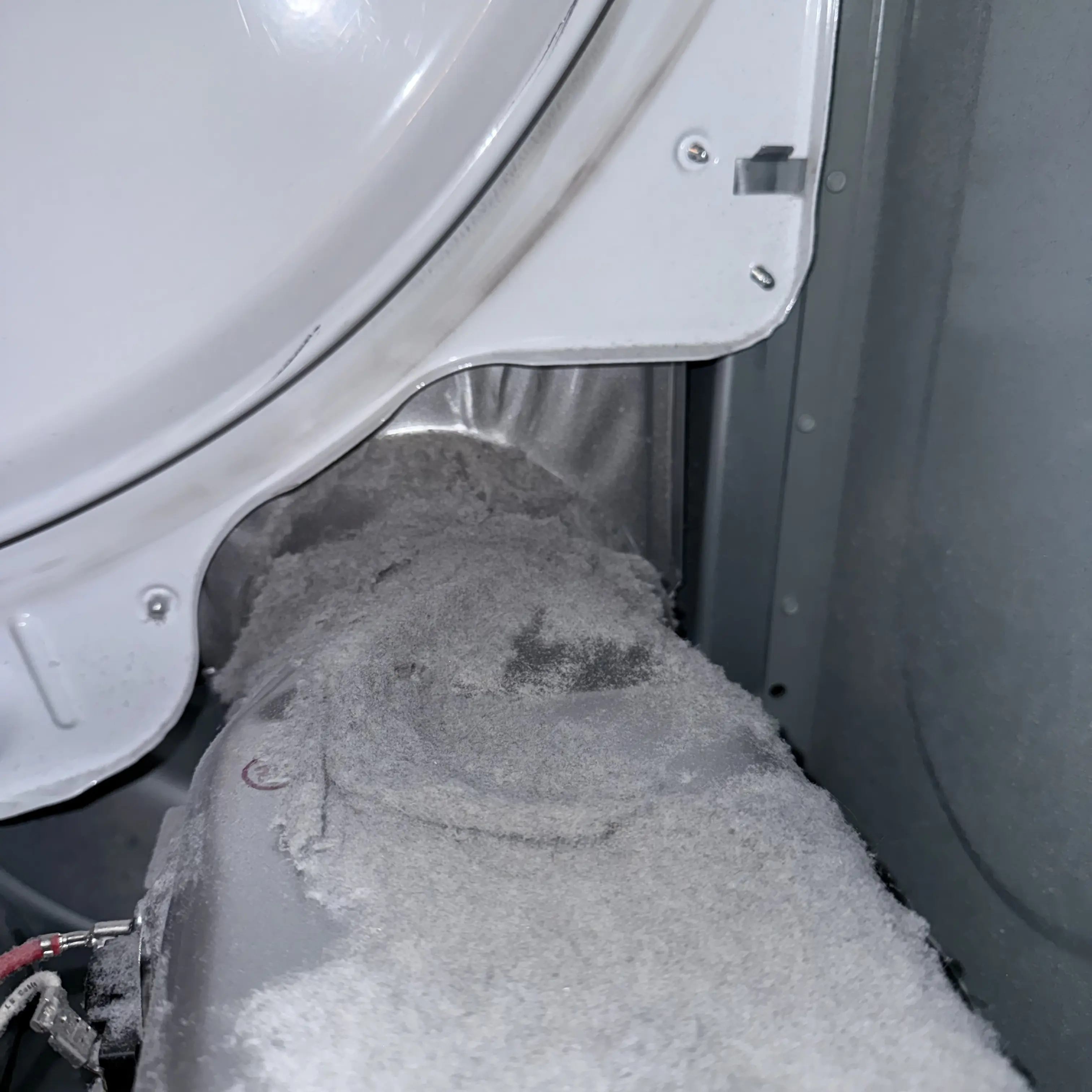 Lint-covered dryer filter clogged with gray, fuzzy accumulated dust