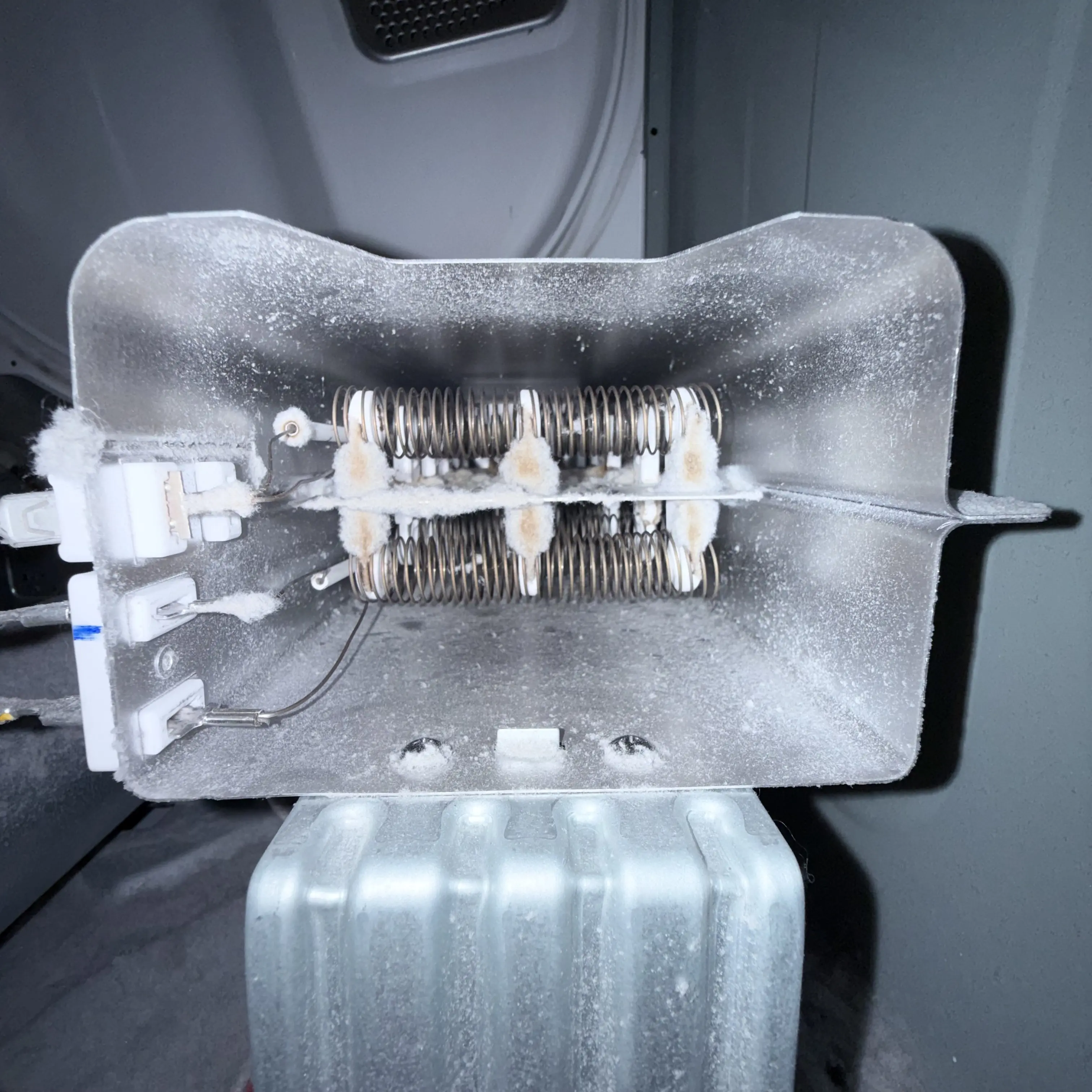 Frost-covered electrical heating element with metal coils inside appliance