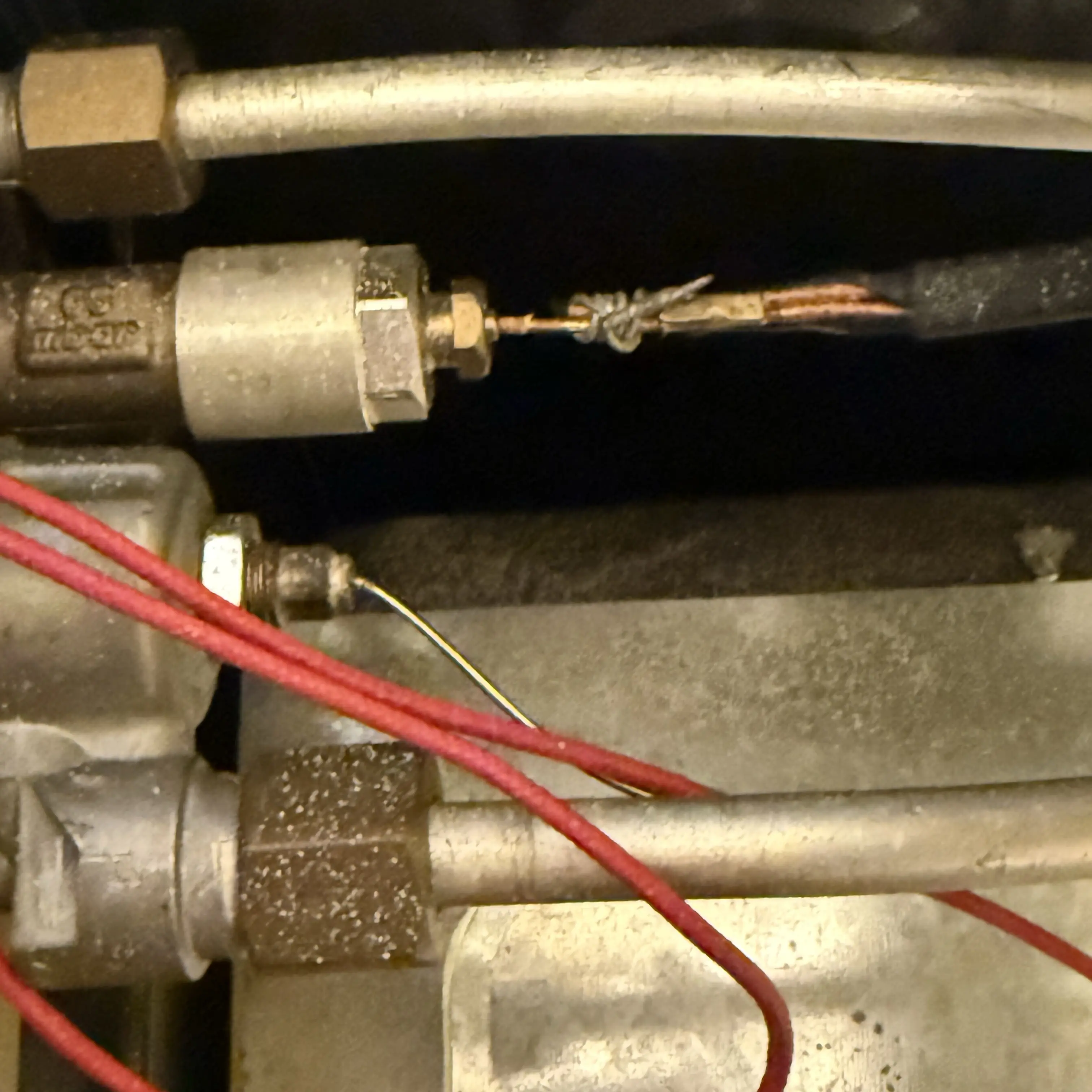 Modern kitchen corner featuring a stainless steel glass-door refrigerator, wooden cabinets, a mounted flat-screen TV, and a coffee machine on the countertop.