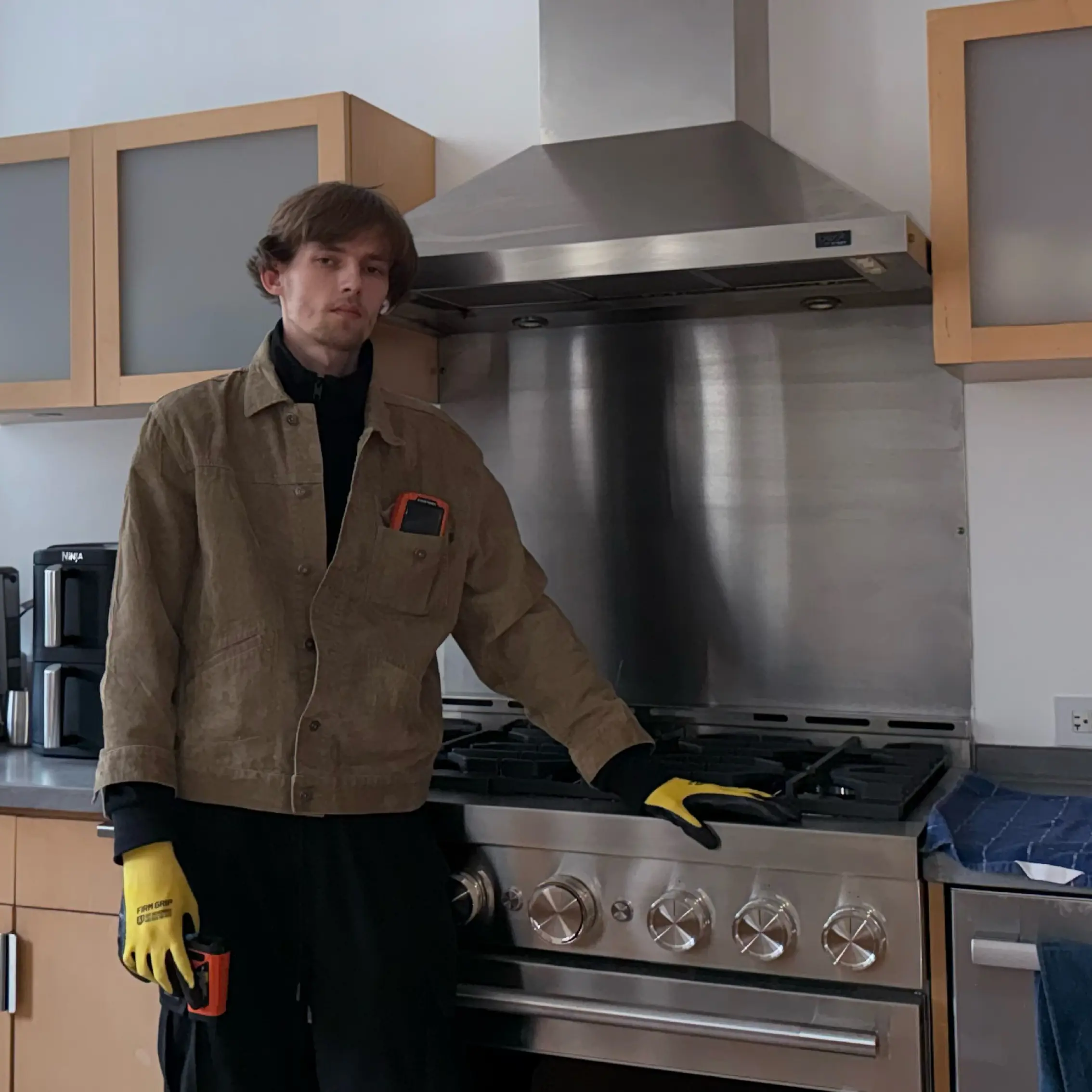 Open freezer filled with food items including ice cream tubs, boxed products, and vegetables, with a person kneeling in front of it.