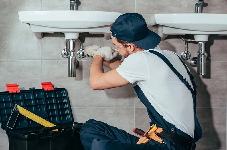 Sunshine Services plumber repairing bathroom sink pipes in Florida