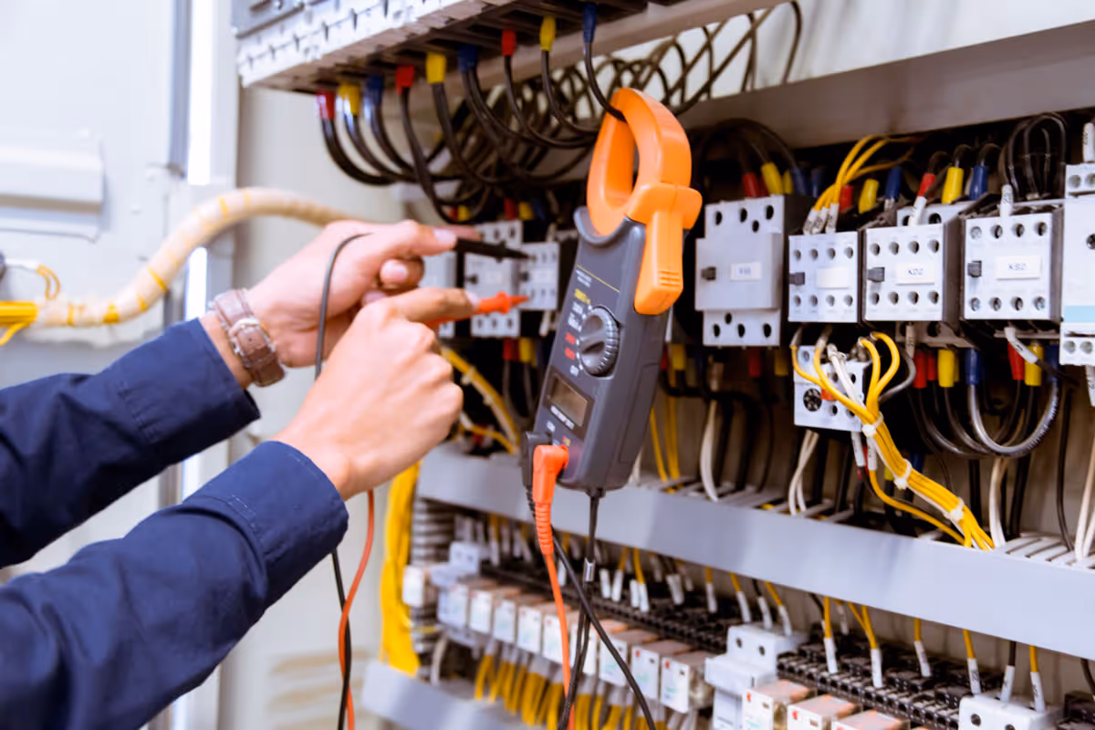 Sunshine Services electrician testing electrical panel wiring with multimeter in Florida