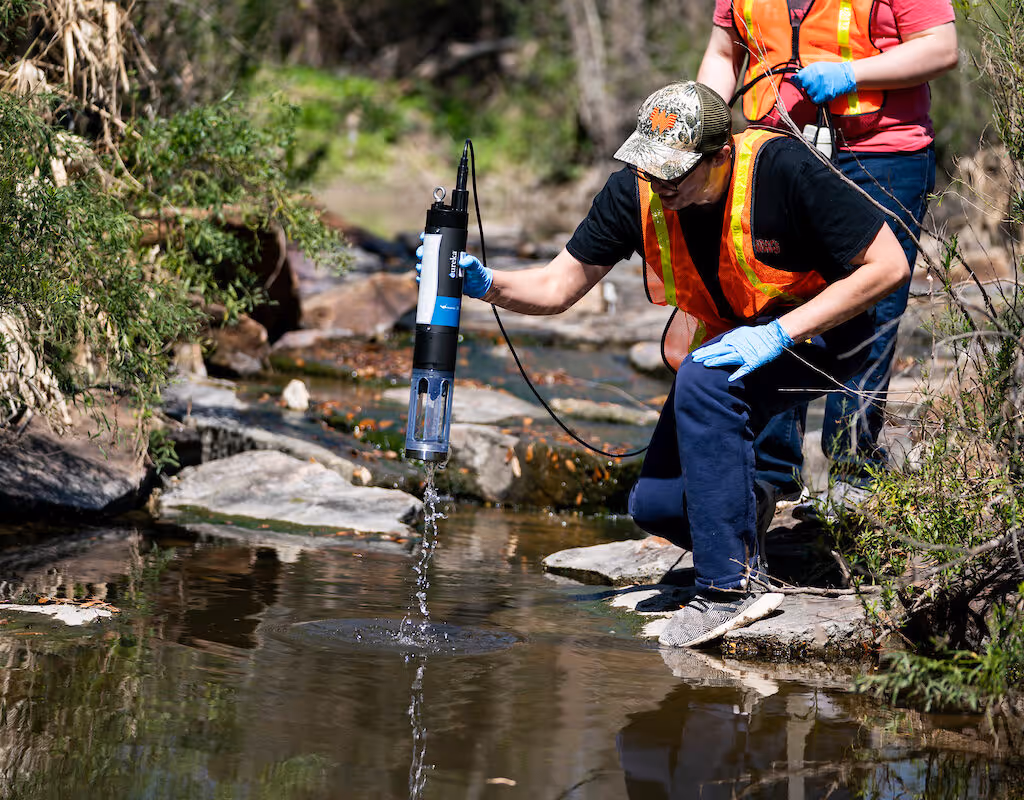Field technicians conducting water quality testing and sampling in a stream in Florida