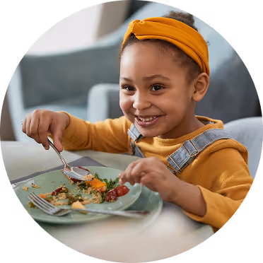 A closeup image of a girl, dressed in orange and smiling