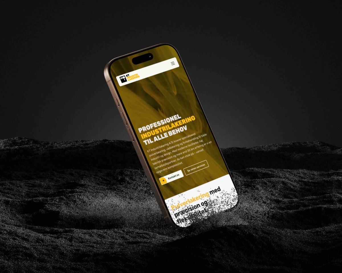 Smartphone viser en hjemmeside for KT Industrilakering med tekst om professionel industrilakering og kontaktmuligheder, placeret i mørkt landskab.
