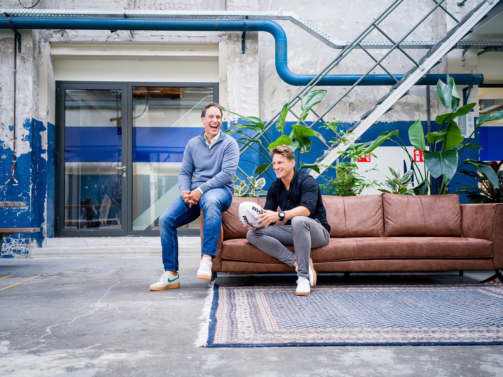 Richard van den Broek en Bart Viguurs de oprichters van de Qube zitten op een bank in de grote ruimte binnen de Qube Den Bosch