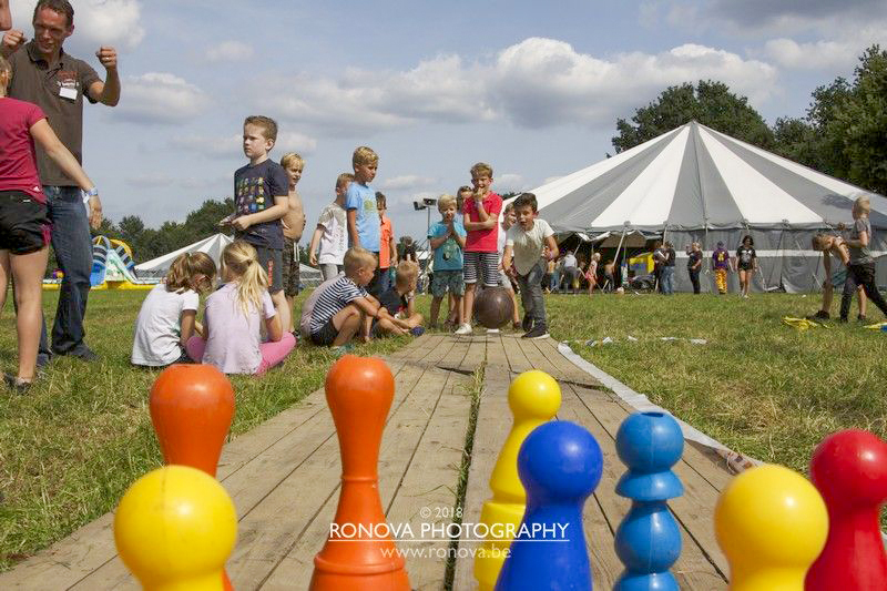 Op de voorgrond; kinderen die buiten aan het kegelen zijn en op de voorgrond de Doe Week hoofdtent.