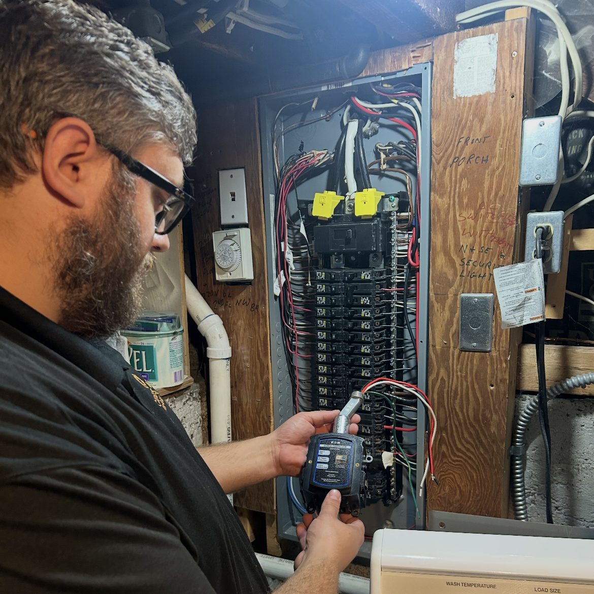 Good Guys electrician installing a whole-home surge protector at a customer's electrical panel.