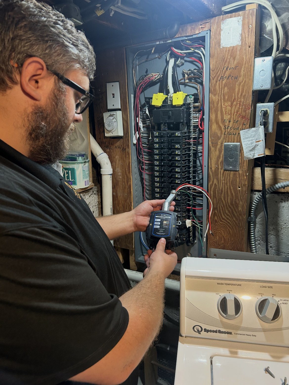 Good Guys electrician Richard installing a whole-home surge protector at a residential panel
