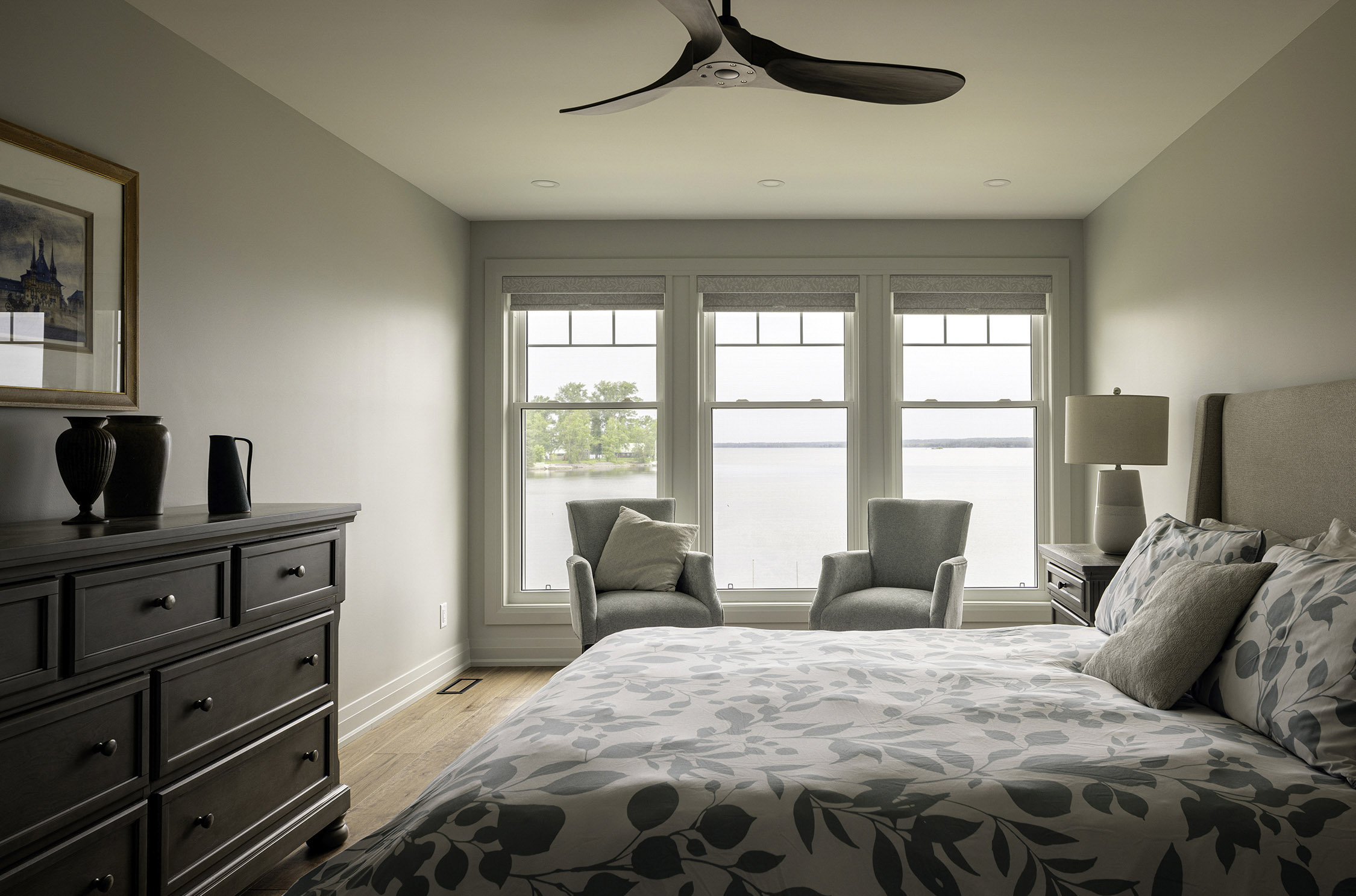 Principal bedroom with a seating area overlooking the water. Architecture: Design Valley. Photography: Kevin Belanger. Copyright 2025.