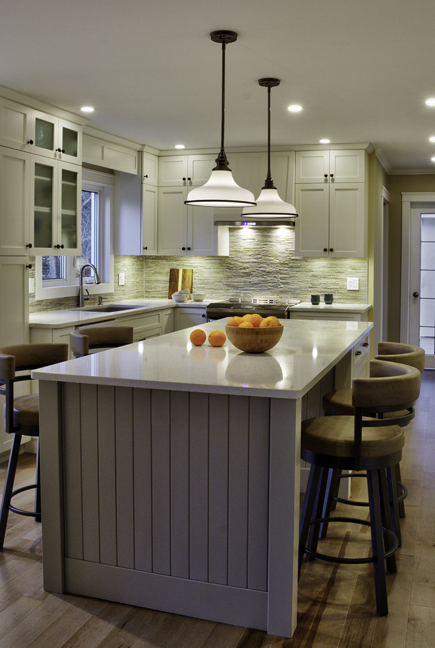 Large kitchen with a big island, elegant lights overtop, and a white aesthetic. Architecture: Design Valley. Photography: Ian Hooper. Copyright 2025.