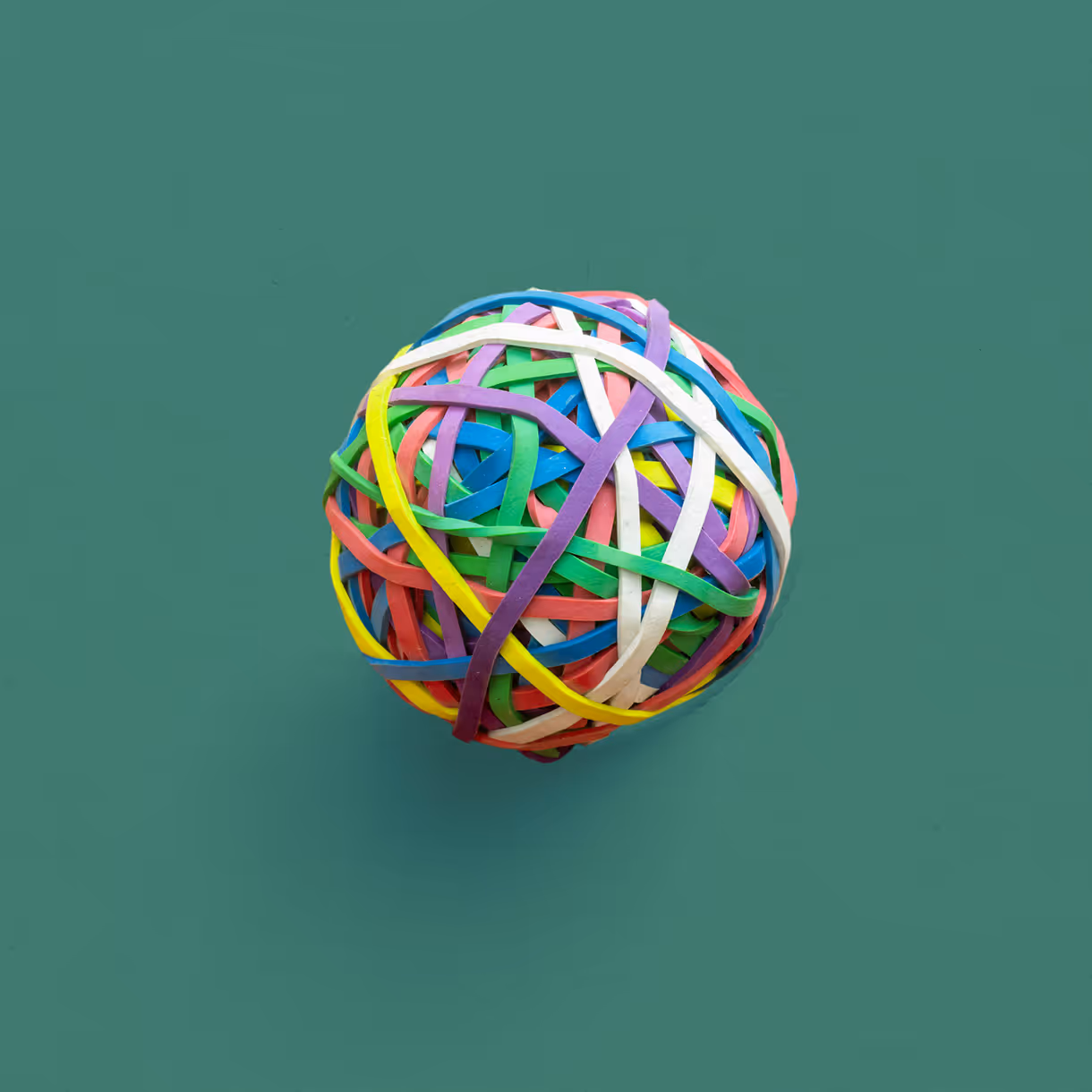 Colorful rubber band ball on a green background
