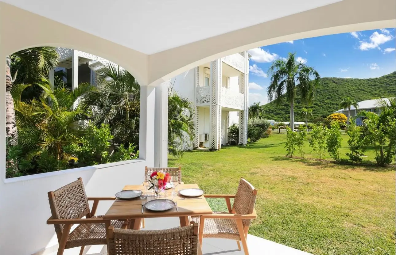 Terrasse ensoleillée avec chaises longues et vue sur le jardin depuis une suite de l’hôtel MIKE