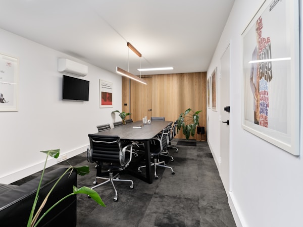 A modern meeting room with long table and chairs.