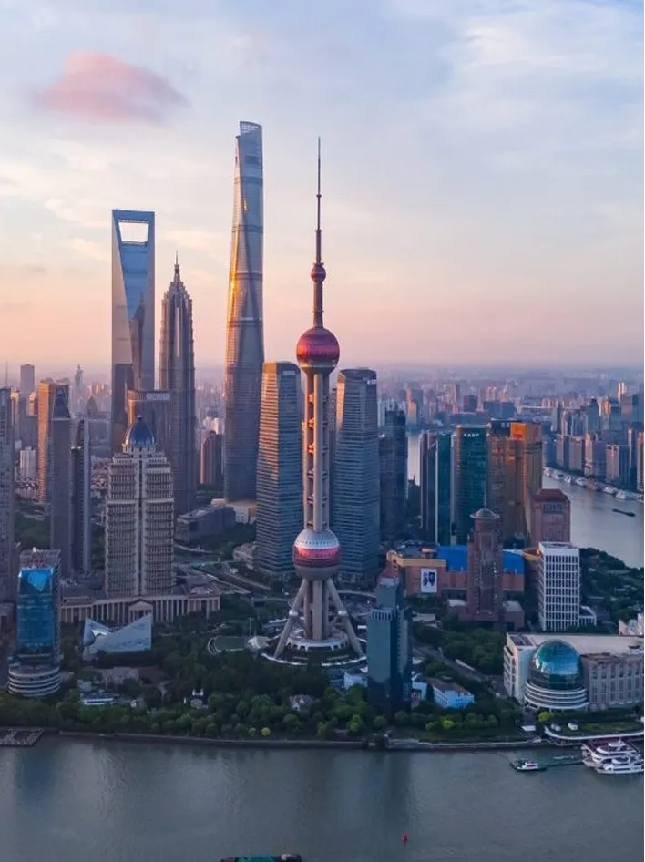 Shanghai skyline featuring the Oriental Pearl Tower and modern skyscrapers at sunrise.