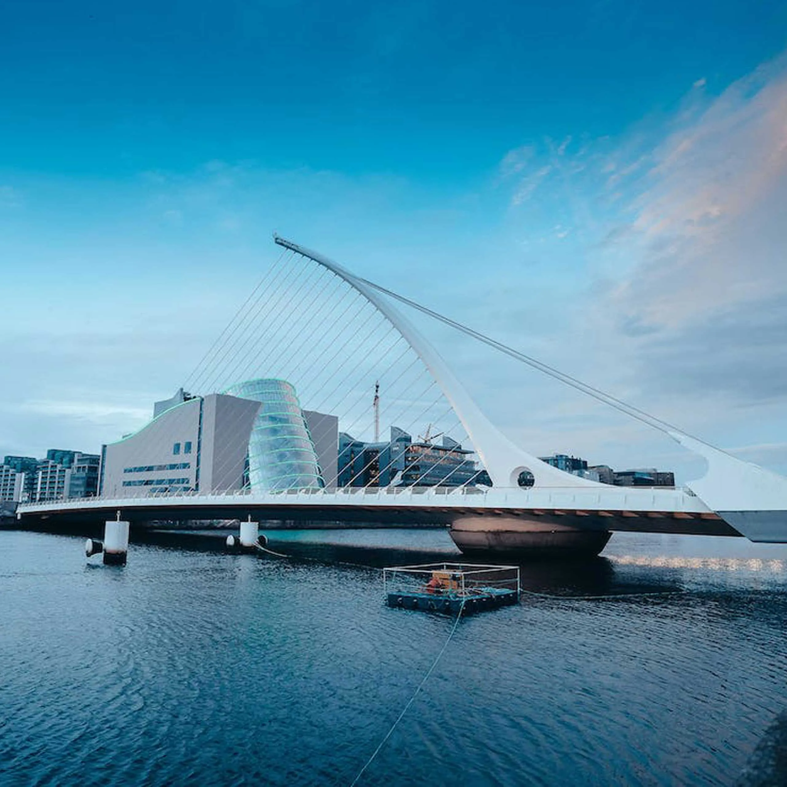 Samuel Beckett Bridge spans the River Liffey in Dublin, with modern architecture in the background.
