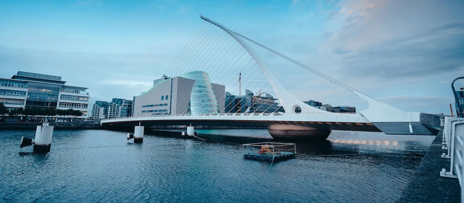 Samuel Beckett Bridge spans the River Liffey in Dublin, with modern buildings in the background.