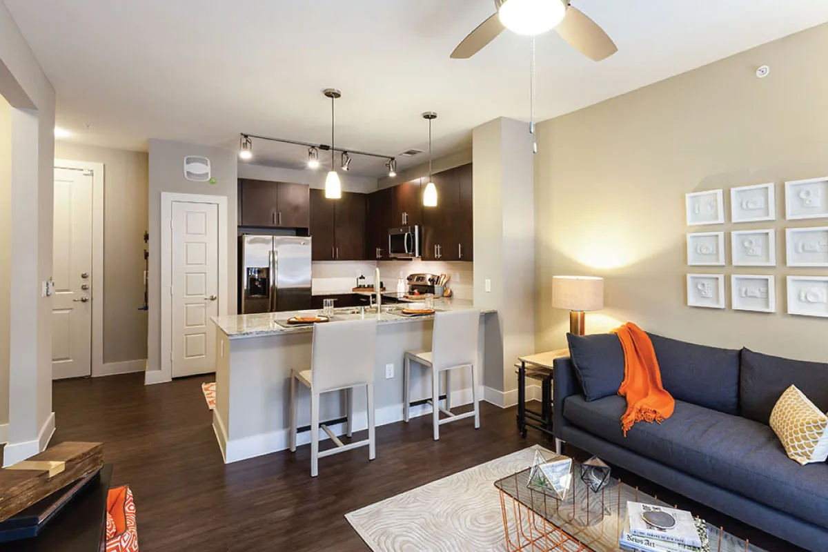 Modern open-concept living space with a kitchen island, dark cabinets, and cozy seating area.