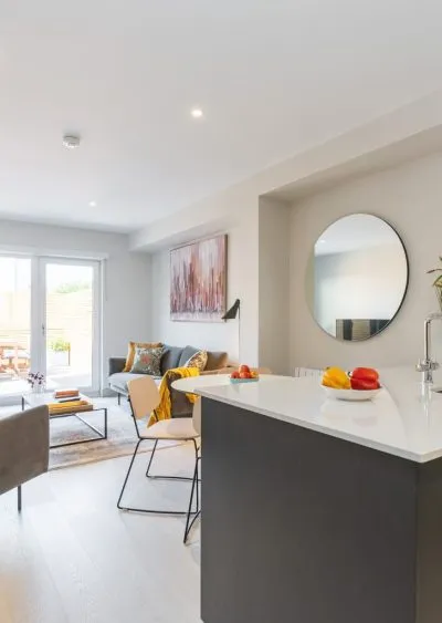 Modern open-plan living area with sleek furnishings, neutral tones, and natural light.