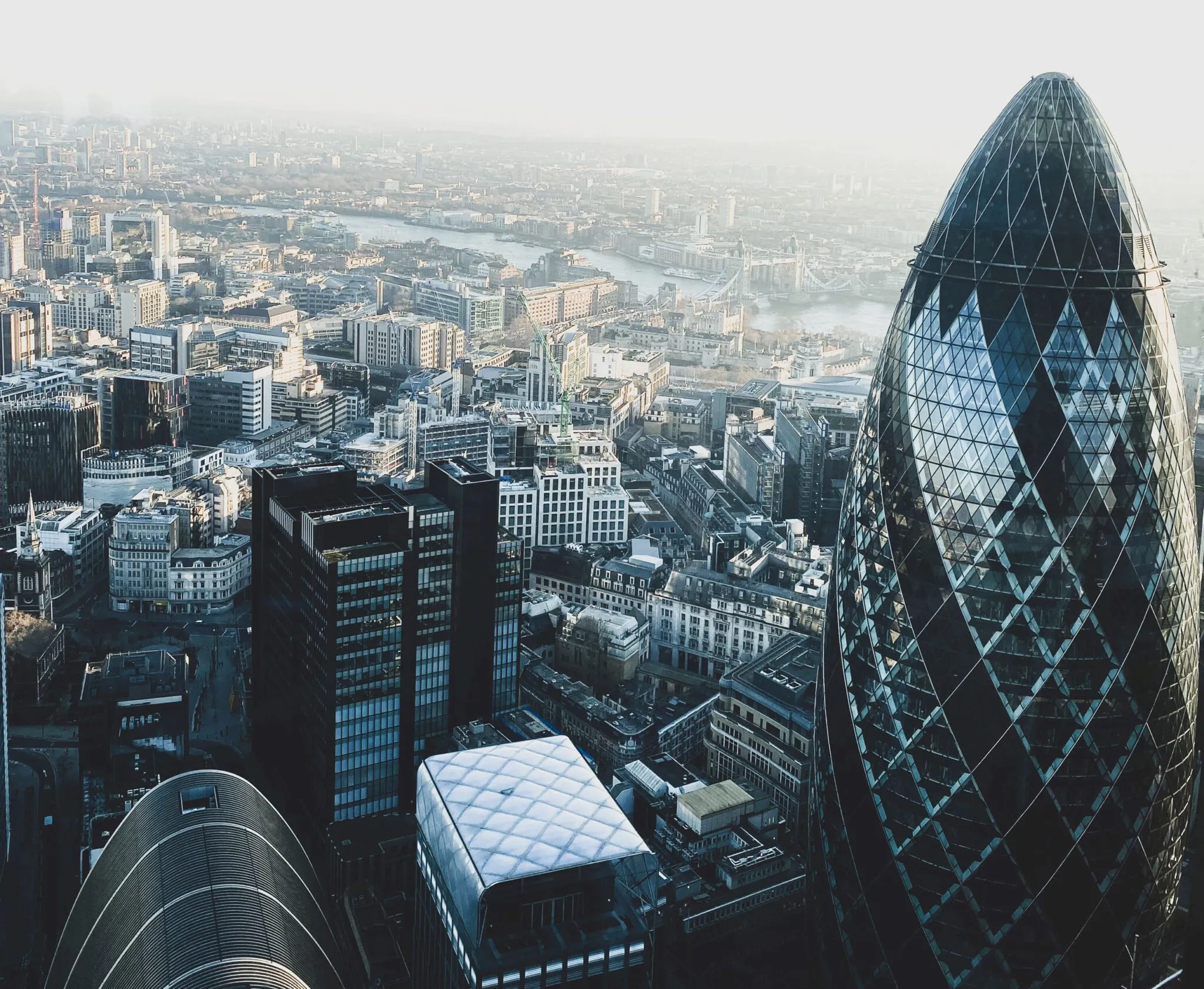 Aerial view of London's skyline featuring the Gherkin and the River Thames in the background.