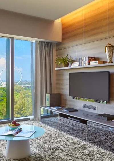 Modern living room with wood paneling, large window, and a view of a Ferris wheel.