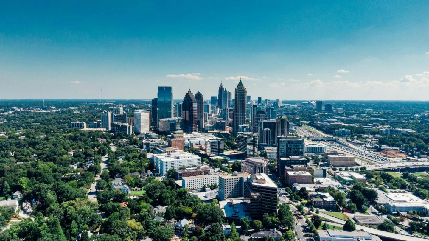 Aerial view of Atlanta's skyline with modern skyscrapers and surrounding greenery.