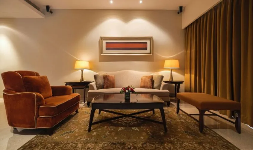 A cozy living room with warm lighting, elegant furniture, and a patterned rug.