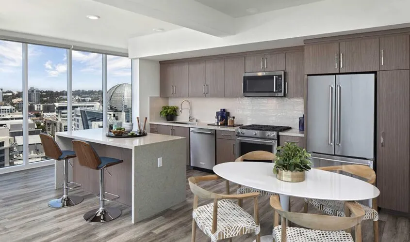 Modern kitchen with sleek cabinetry, stainless steel appliances, and city views through large windows.