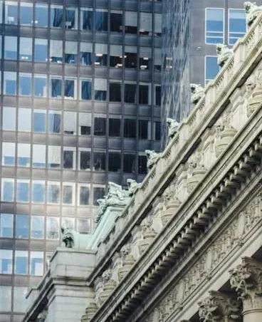 Ornate classical architecture contrasts with modern glass skyscrapers in an urban setting.