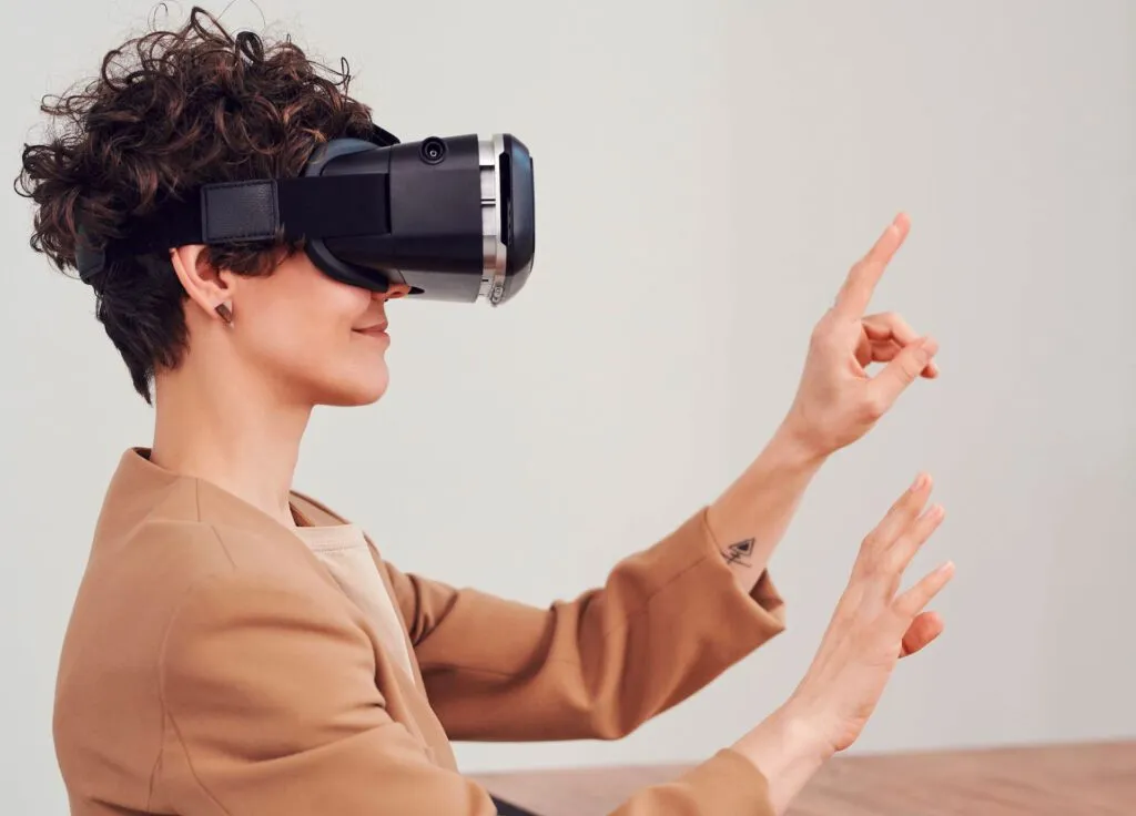 A person wearing a VR headset interacts with a virtual environment using hand gestures.
