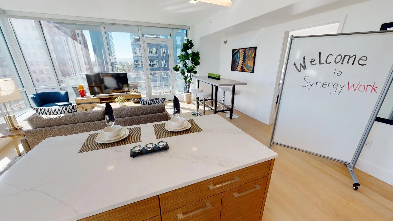 Modern open-concept workspace with natural light, sleek furniture, and cityscape views.