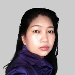 A person with long black hair wearing a purple jacket, set against a plain gray background.