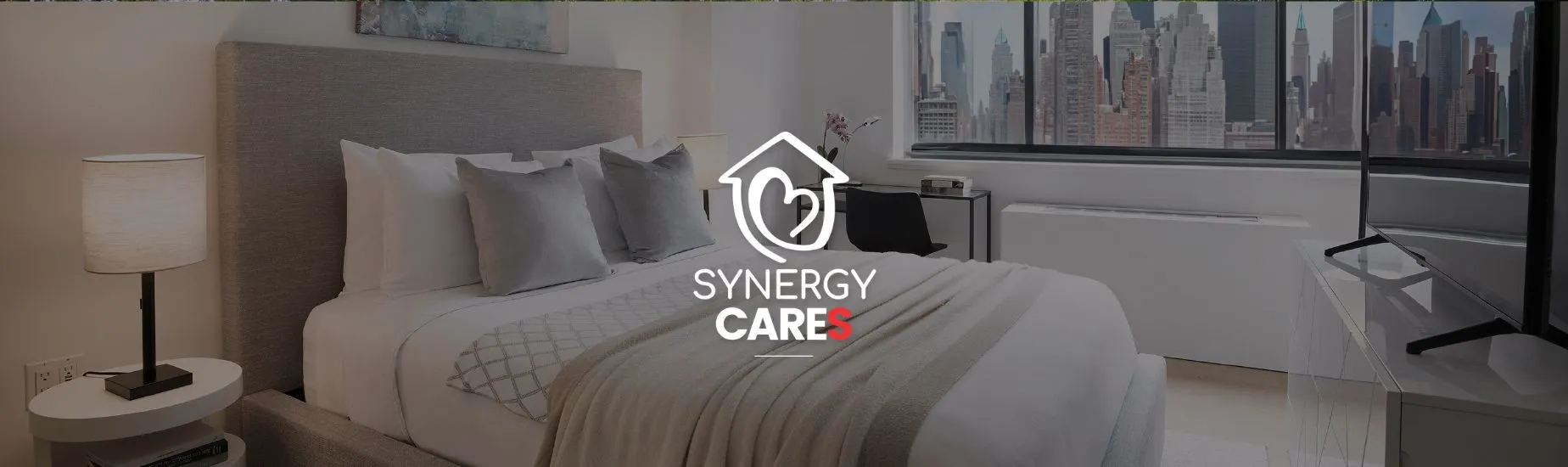 Modern bedroom with city skyline view, neutral decor, and Synergy Cares logo overlay.