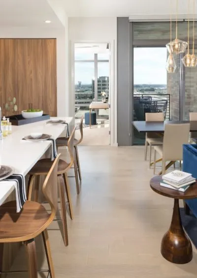 Modern open-concept kitchen and dining area with wood accents and contemporary furnishings.