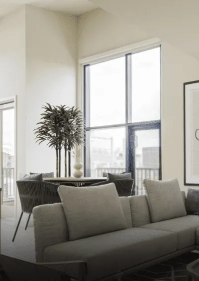 Modern living space with neutral tones, large windows, and minimalist furniture arrangement.