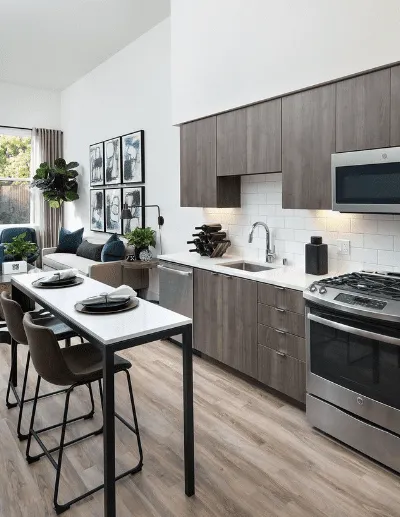 Modern kitchen with wood cabinets, sleek appliances, and an open dining-living area.