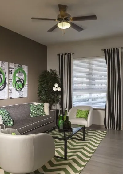 Modern living room with green accents, striped curtains, and geometric decor elements.