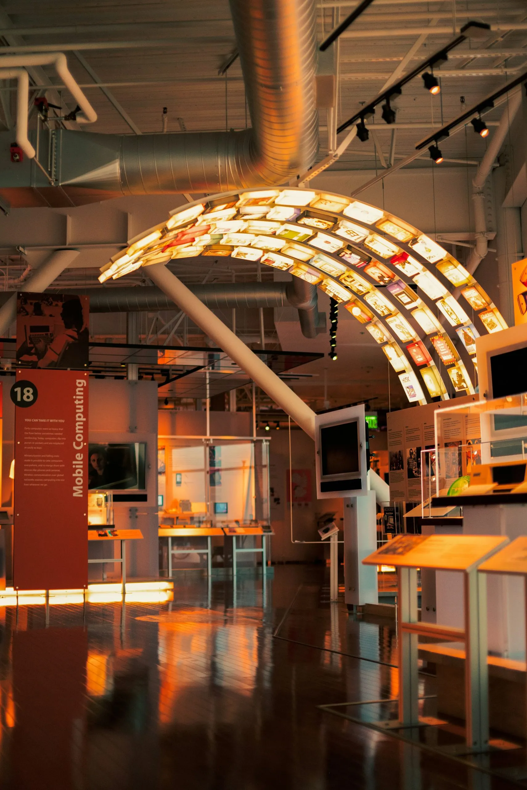 A modern exhibit showcasing mobile computing history, featuring illuminated displays and devices.