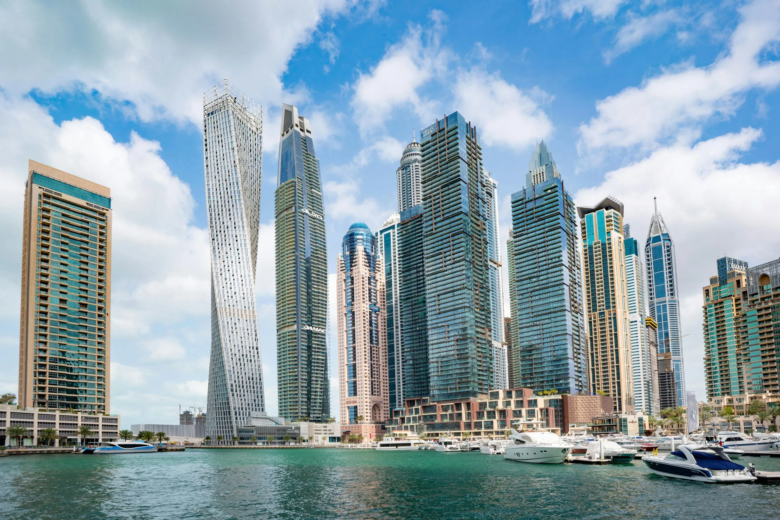 Dubai Marina skyline featuring modern skyscrapers, luxury yachts, and waterfront architecture.