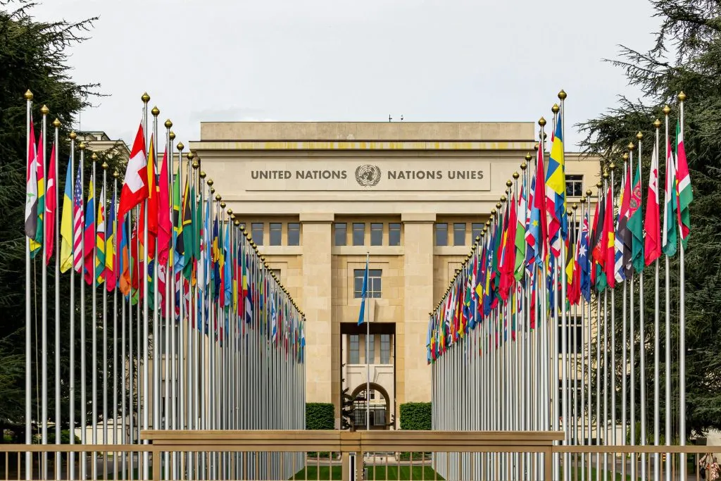 The United Nations building is surrounded by a display of member states' flags in Geneva, Switzerland.