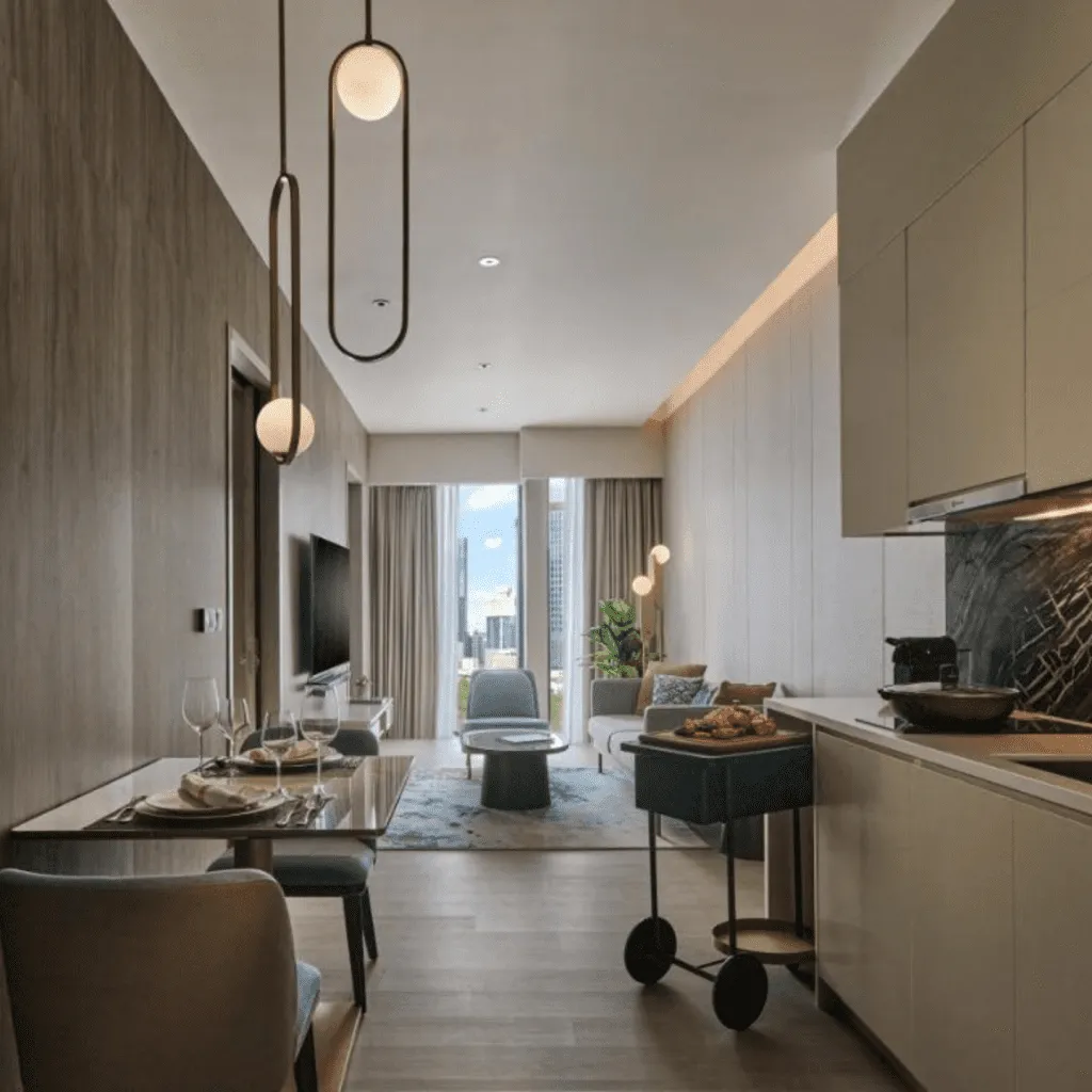 Modern apartment interior with open kitchen, dining area, and living space overlooking city views.