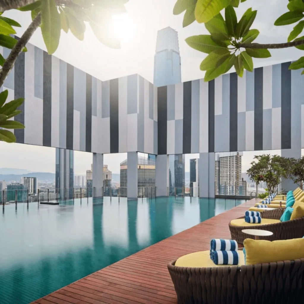 A modern rooftop infinity pool with city views, framed by striped architectural panels.