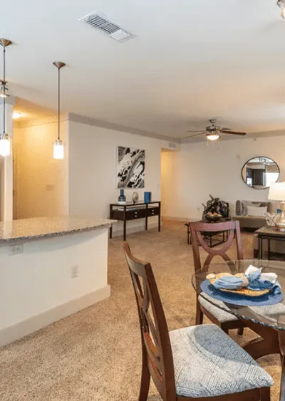 Open-concept living space with modern lighting, carpeted floors, and neutral-toned decor.